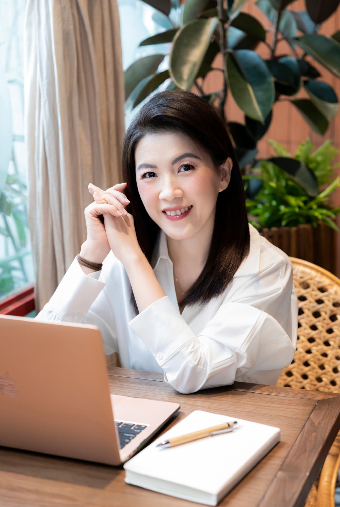 Người hướng dẫn workshop ngồi bên bàn làm việc với laptop và sổ tay